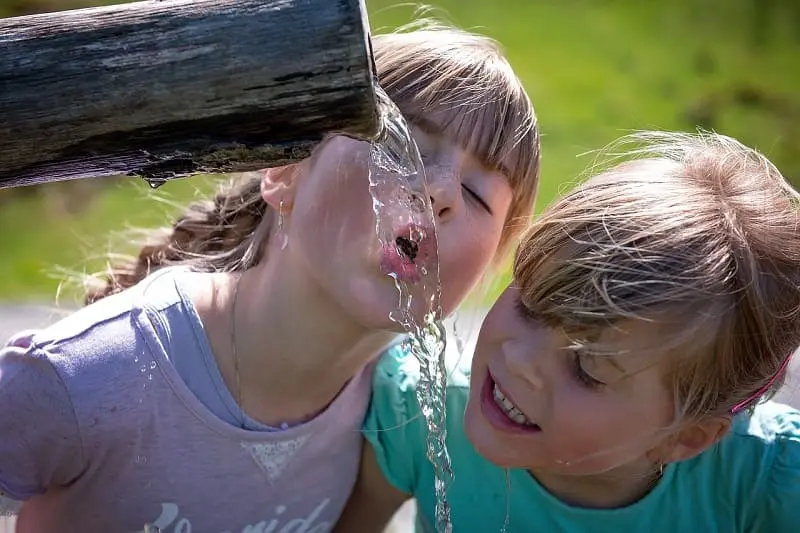Bambini bevino acqua dalla fonte